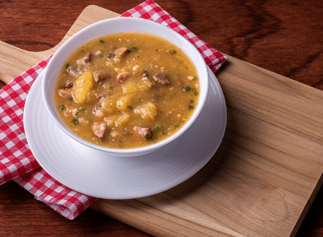 Caldo de mocotó caseiro com legumes servido em tigela branca
