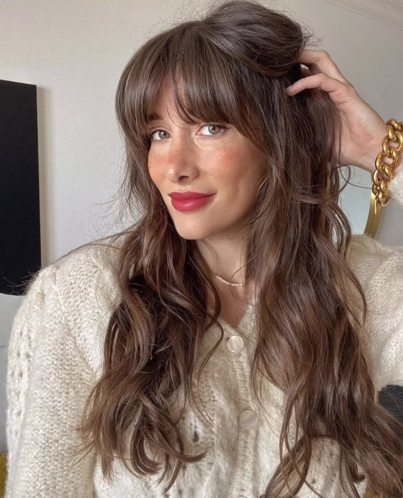 Corte médio com franja Bardot, com cabelo solto e suave, inspirado na atriz Brigitte Bardot.