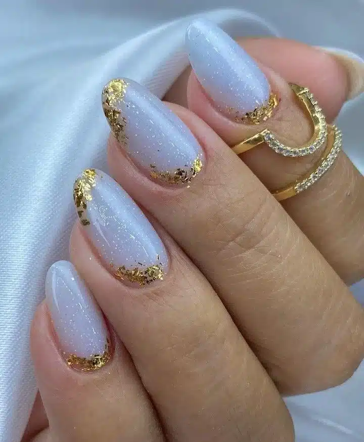 Unhas com detalhes em dourado nas pontas, criando um visual sofisticado e elegante.
