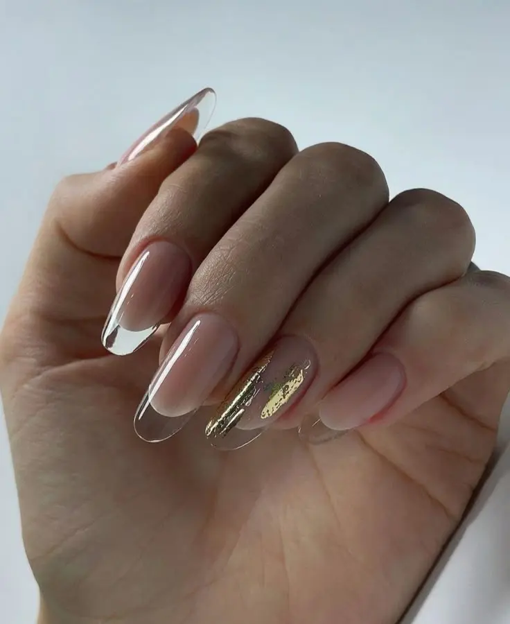 Unhas com efeito vidro translúcido e detalhes dourados.