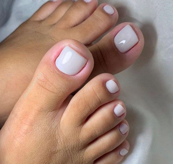 Unhas dos pés com esmalte branco cremoso em acabamento delicado