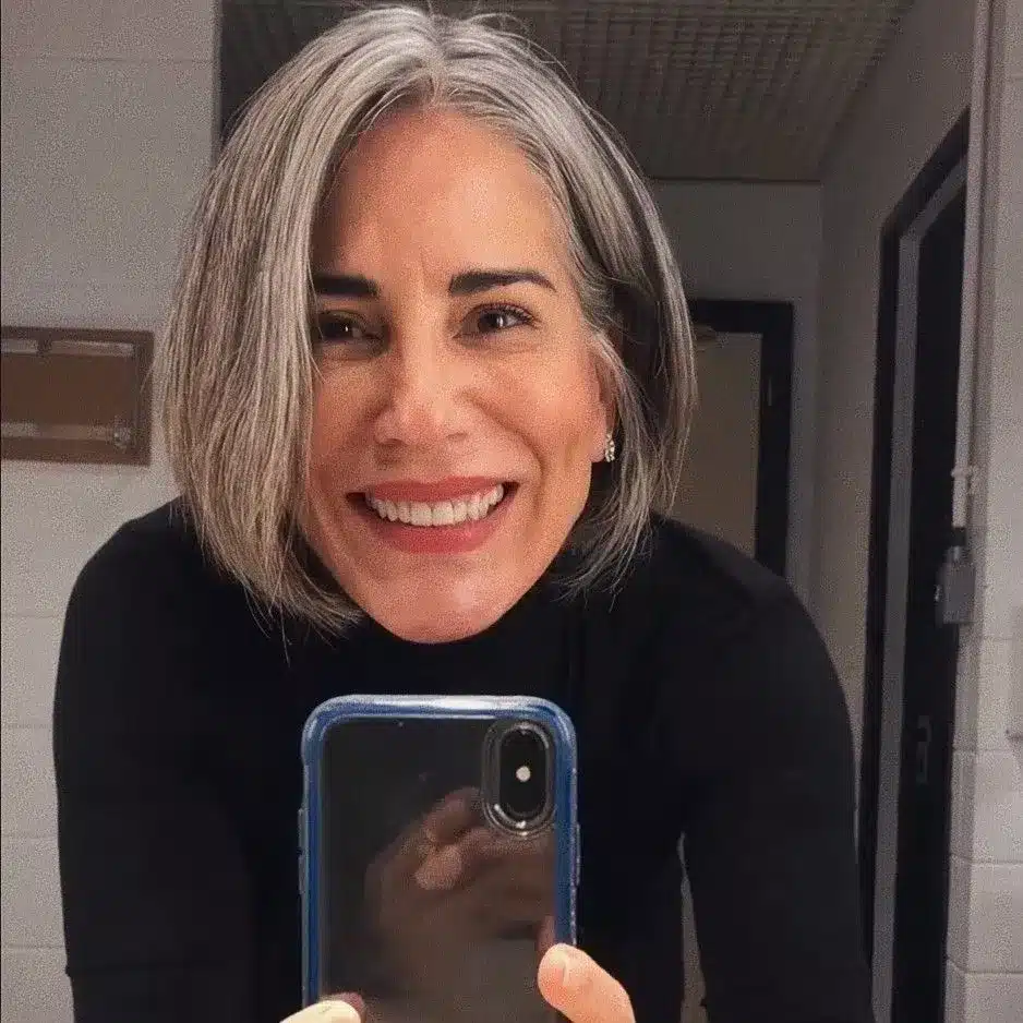 Glória Pires com cabelos grisalhos e corte moderno, refletindo autoestima e elegância.