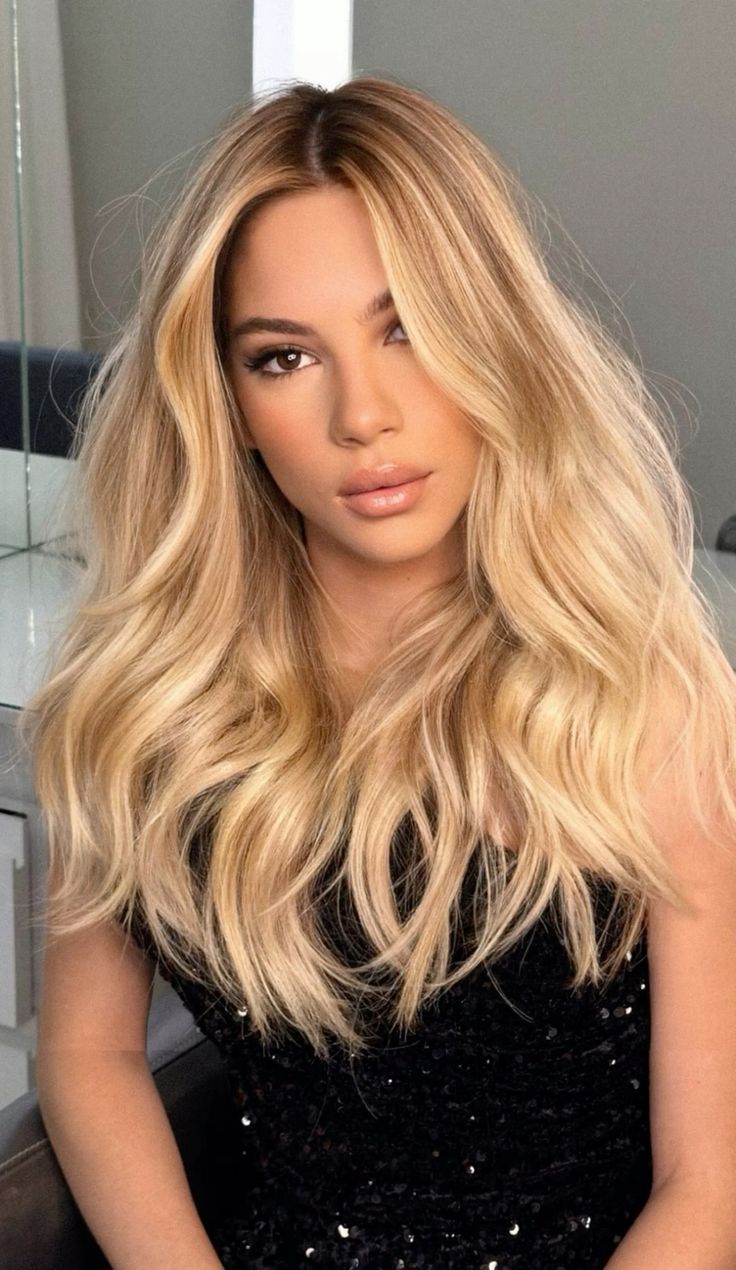 Mulher com cabelo loiro areia ondulado, longo e volumoso