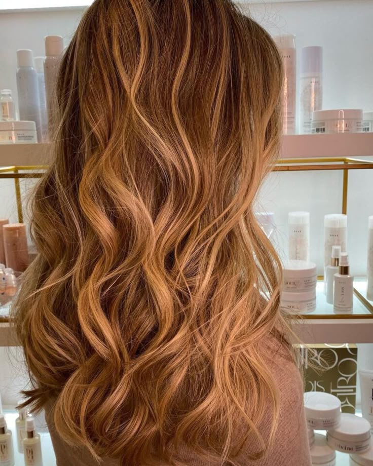 Cabelo loiro mel ondulado visto de costas em ambiente de salão