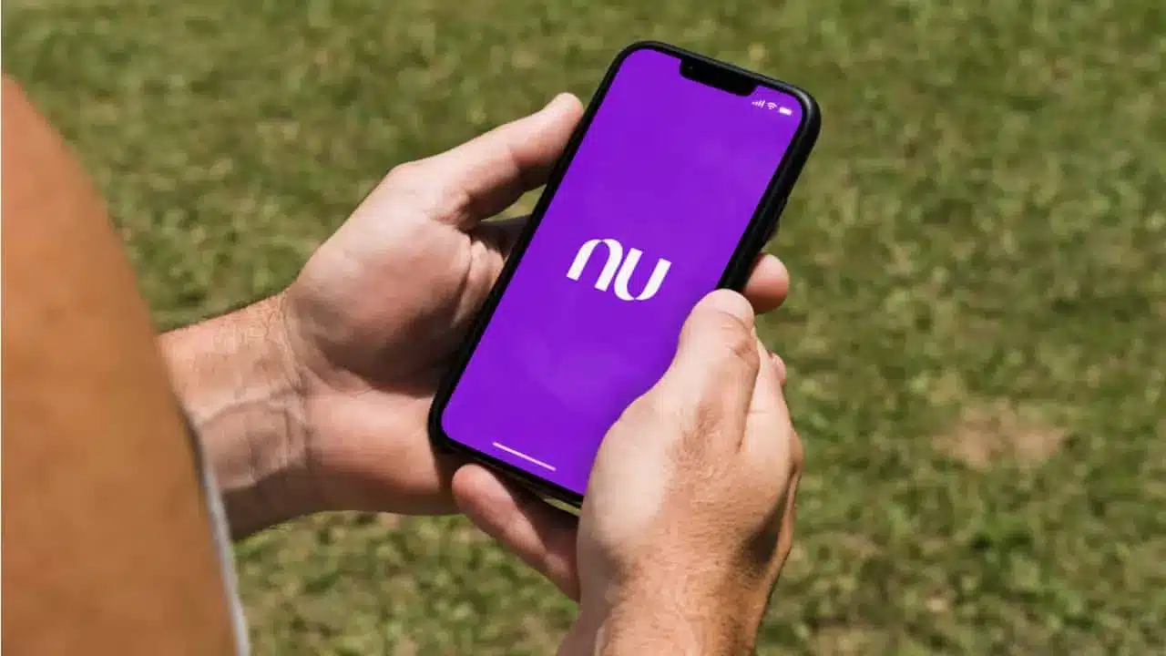 Tela do celular exibindo o aplicativo do Nubank com logo roxo enquanto o usuário relata problemas de instabilidade.