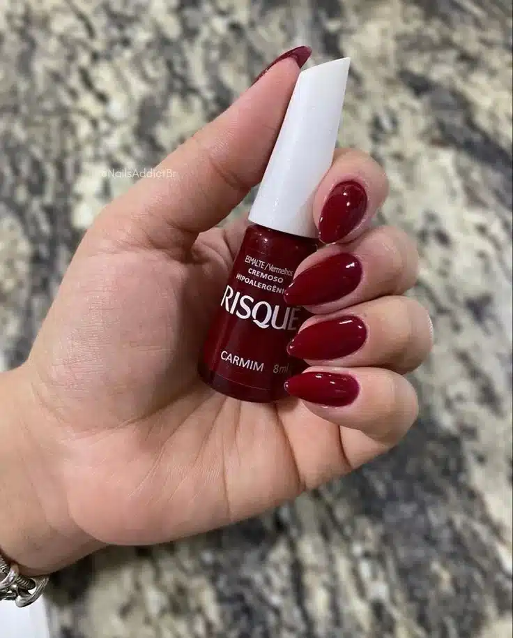 Unhas com esmalte vermelho queimado, ideal para um look sofisticado e moderno.
