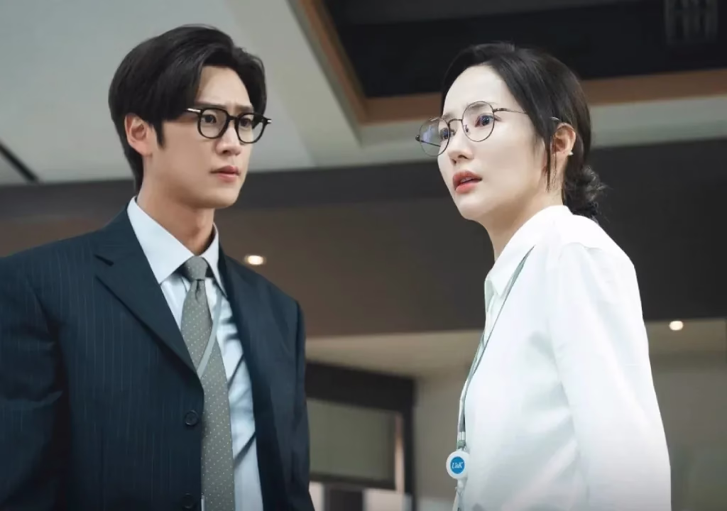 Cena do dorama "A Esposa do Meu Marido" com os protagonistas em um escritório