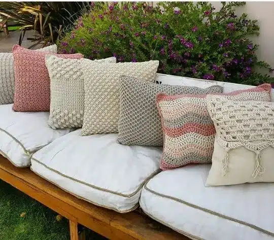 Almofadas com texturas mistas e técnicas variadas, criando um contraste entre relevos e áreas lisas.