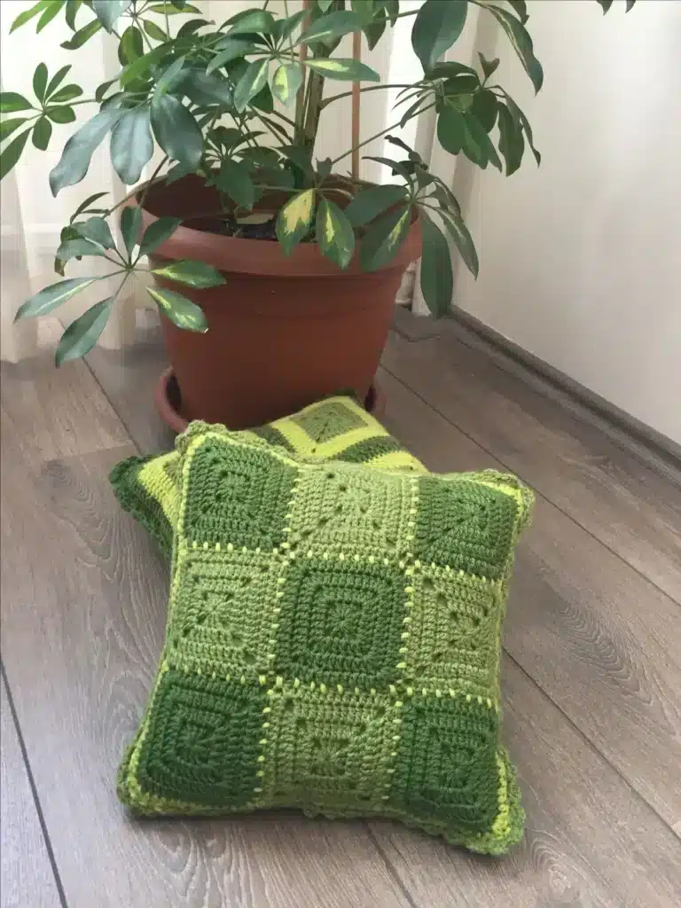 Almofada de crochê com efeito degradê verde, adicionando fluidez e modernidade ao ambiente.