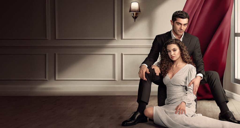 Casal sentado no chão em cena dramática de novela turca