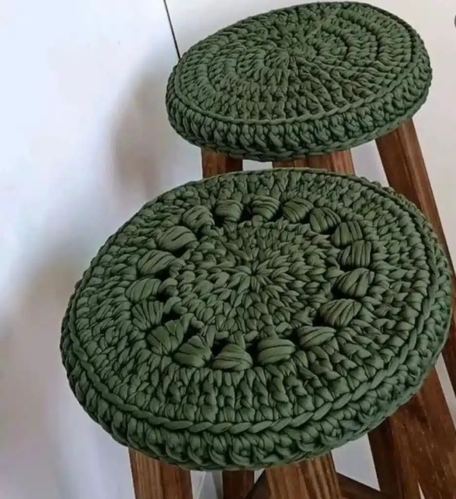 capas de crochê verdes em fio de malha sobre banquetas de madeira