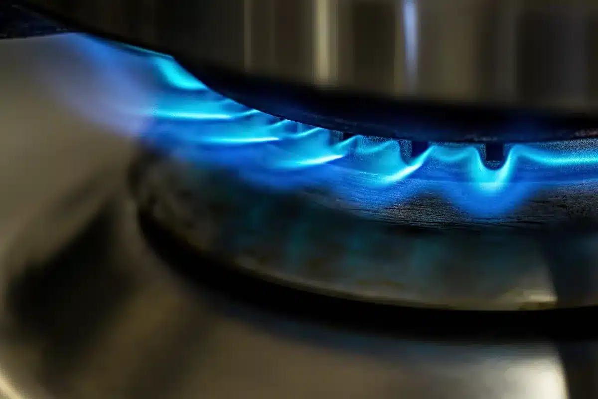 Chama azul do fogão acesa em detalhe.