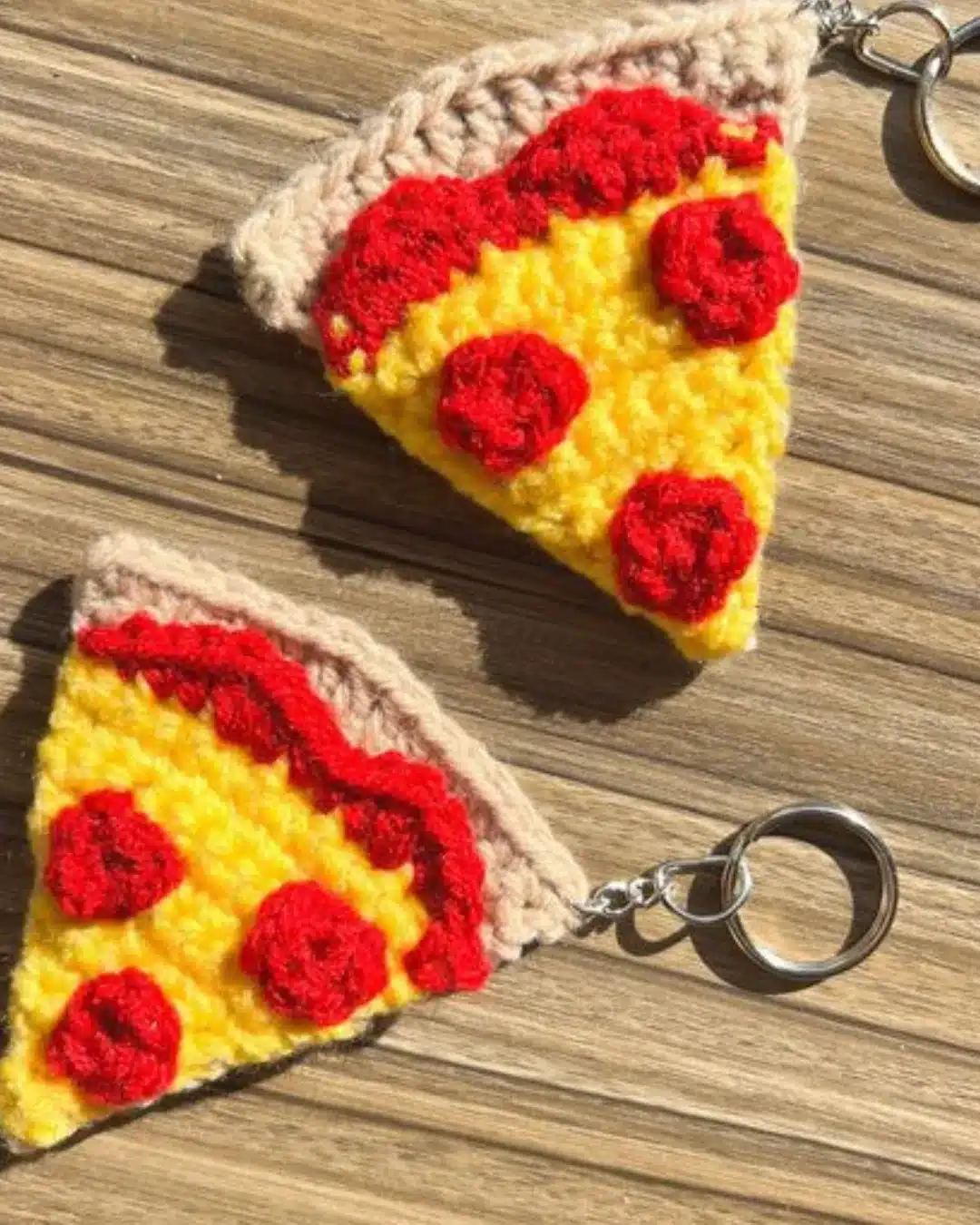 Chaveiros de crochê em formato de fatia de pizza com pepperoni.