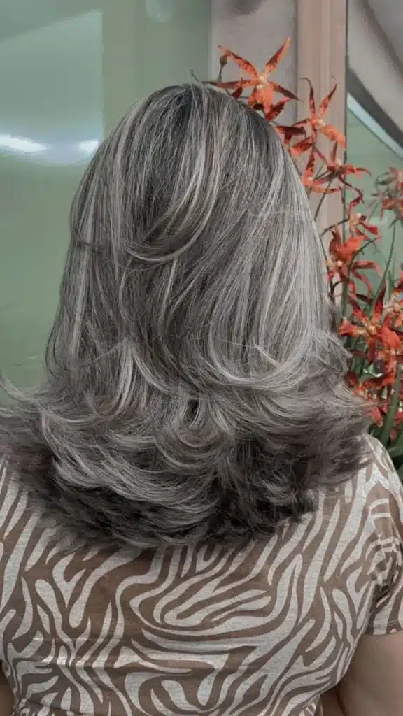 Imagem de corte médio com ondas, com cabelo branco e movimento natural.