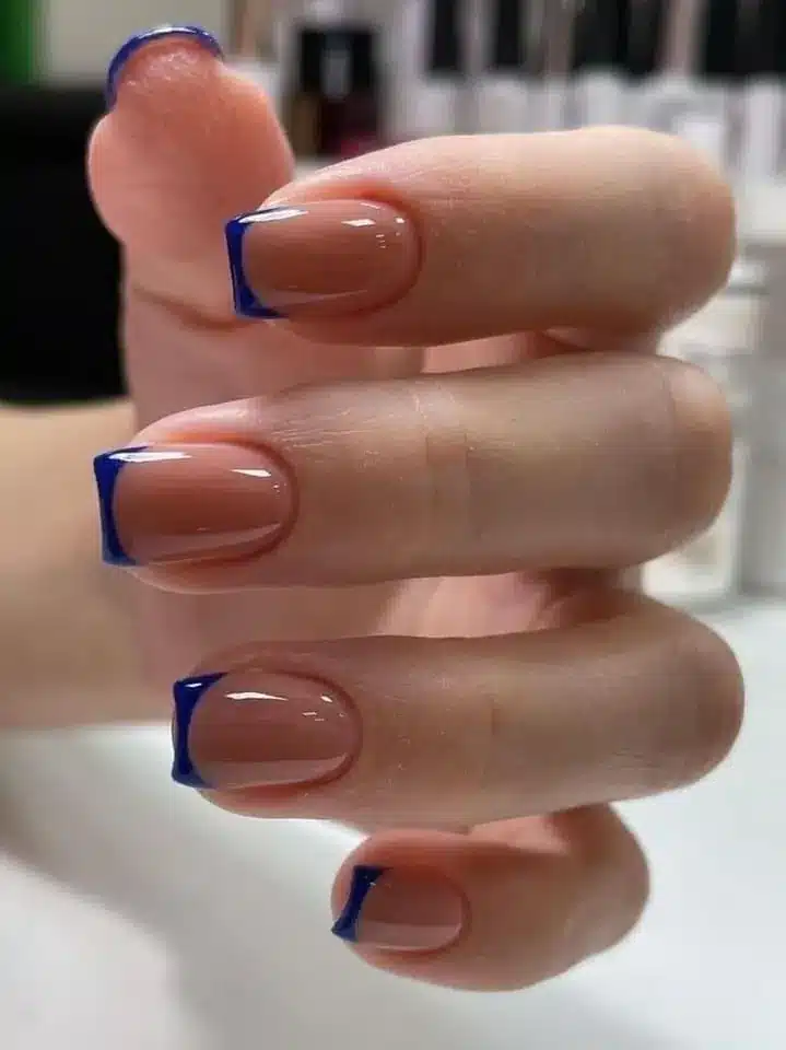 Unhas com francesinha azul moderna sobre base nude