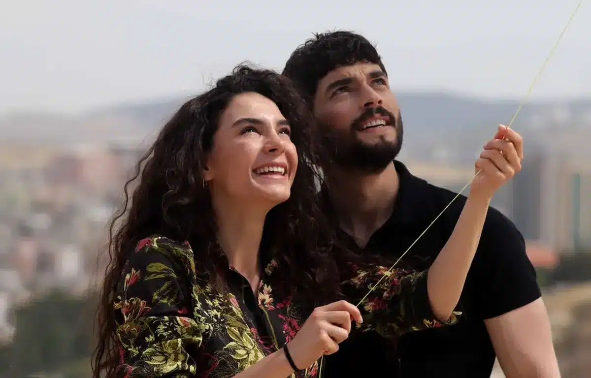 Cena de romance e tensão de Hercai: Amor e Vingança, com o casal principal desfrutando de um momento ao ar livre.