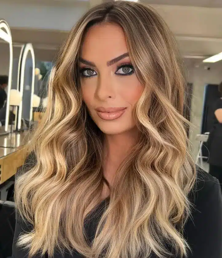 Mulher com cabelo loiro dourado em ondas suaves, destacando a luminosidade e suavidade do tom.