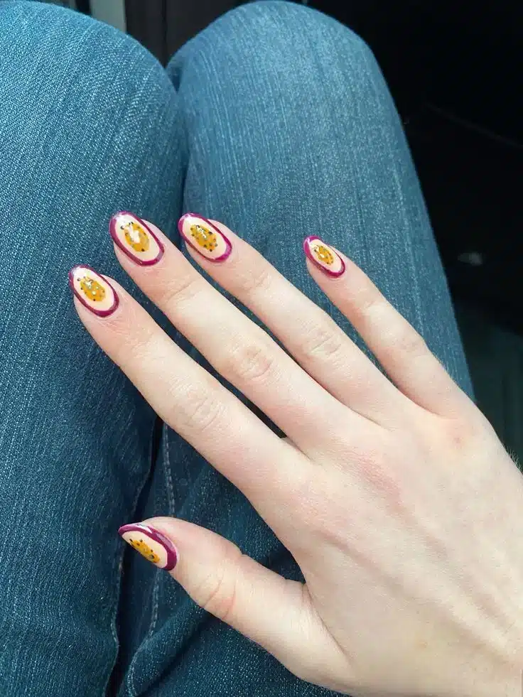 Unhas decoradas com arte de maracujá, inspiradas na tendência de frutas exóticas nas unhas