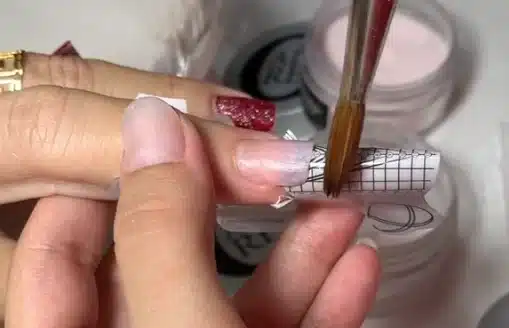 Aplicação de unhas de porcelana com pincel, técnica popular no TikTok.