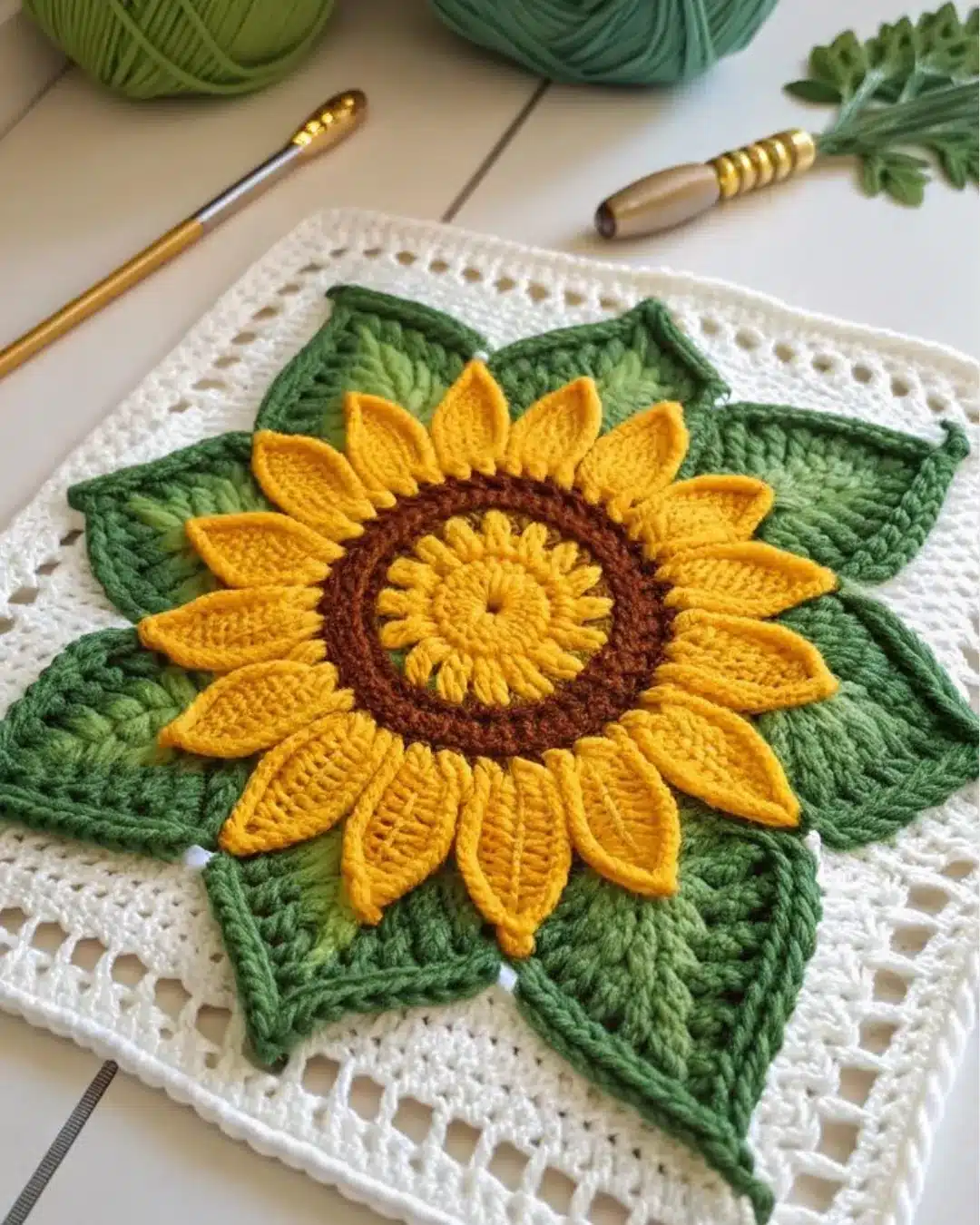 Girassol em crochê com folhas verdes aplicadas em técnica 3D.