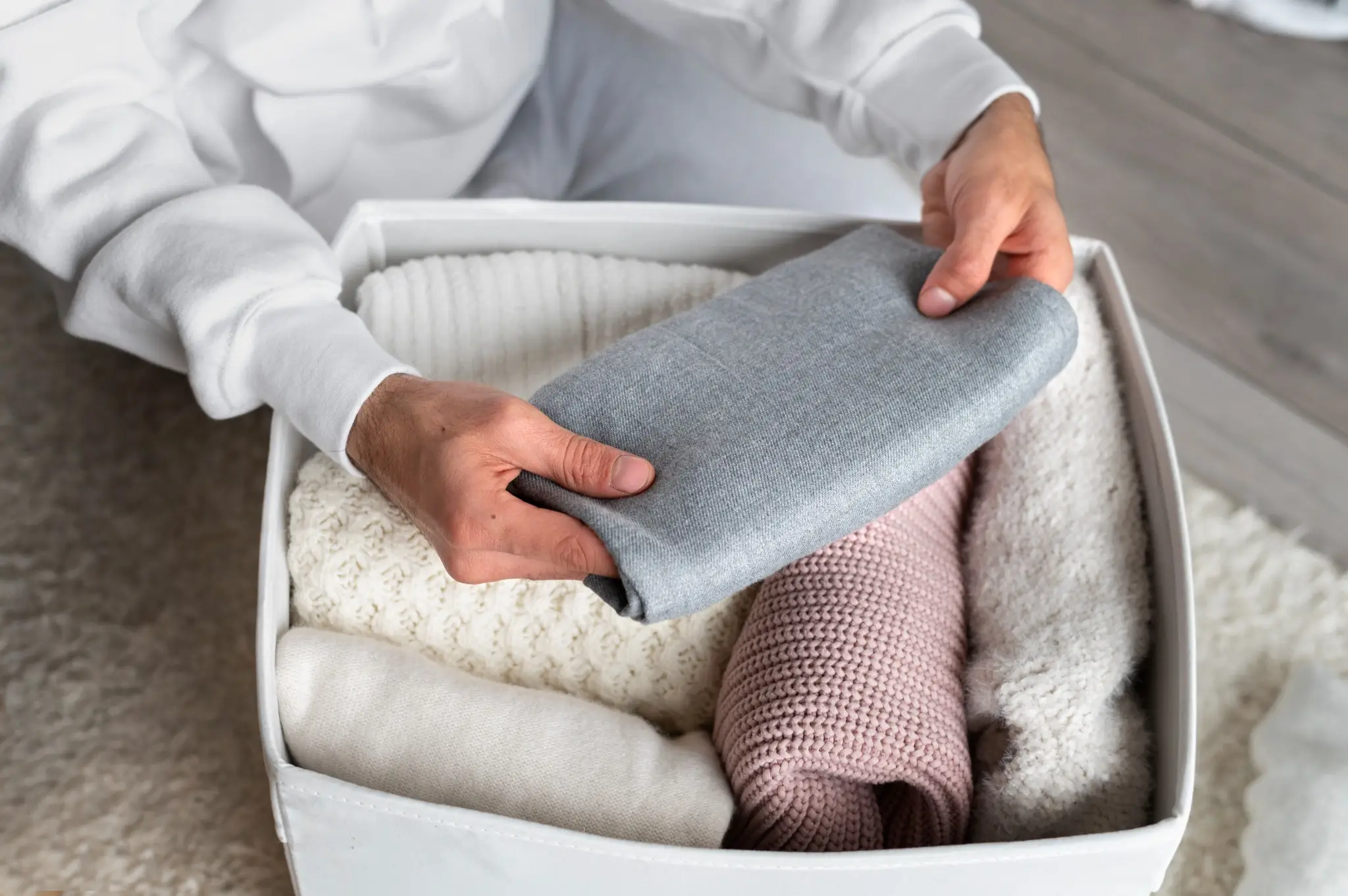 Dobrando roupas de forma eficiente, com foco em técnicas de rolagem e cubos.