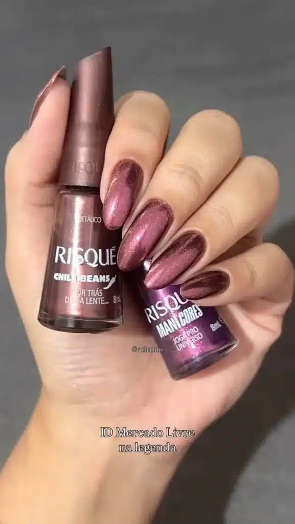 Unhas pintadas com esmaltes metálicos Risqué Chili Beans e Risqué Mani Cores - Jogo Pro Universo, apresentando tons de rosa e roxo com brilho.