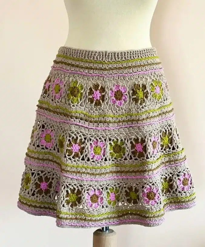 Saia de crochê com barrado de flores coloridas em tons de rosa, verde e lilás