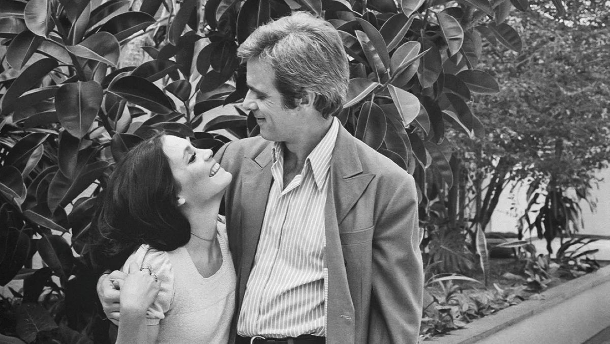 Casal sorridente em cena romântica de novela clássica da TV Globo.