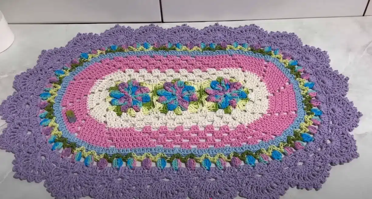 Tapete de crochê oval com flores catavento e tulipas em candy colors.