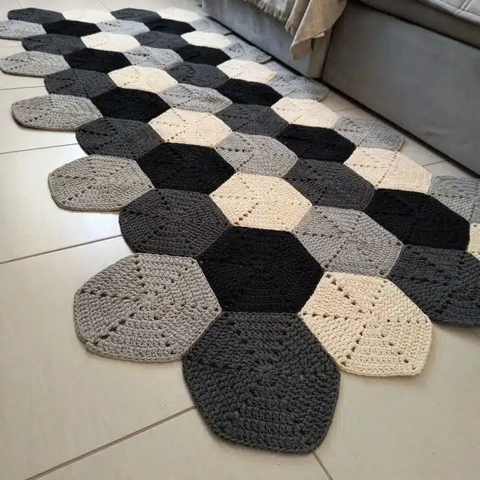 Tapete geométrico moderno com hexágonos nas cores cinza, preto, creme e bege.