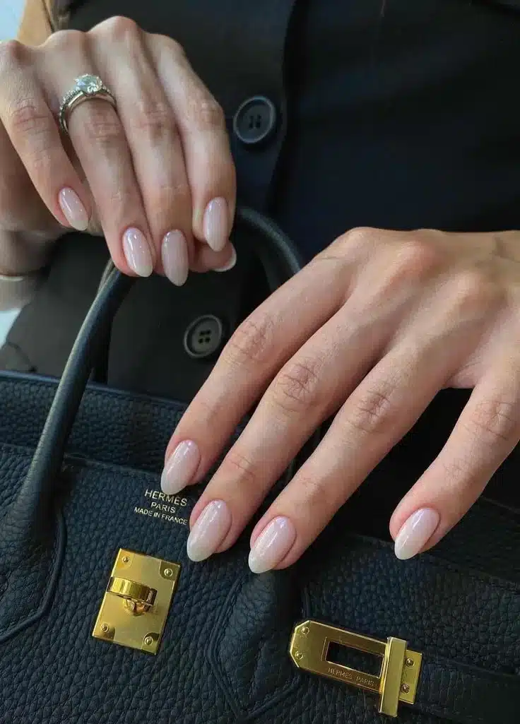 Unhas amendoadas com esmalte rosé, destacando a delicadeza dos dedos e a elegância do formato.