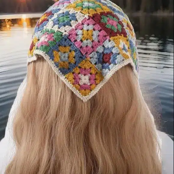 Bandana de crochê colorida com padrões de quadrados, em tons vibrantes de rosa, amarelo, azul e verde