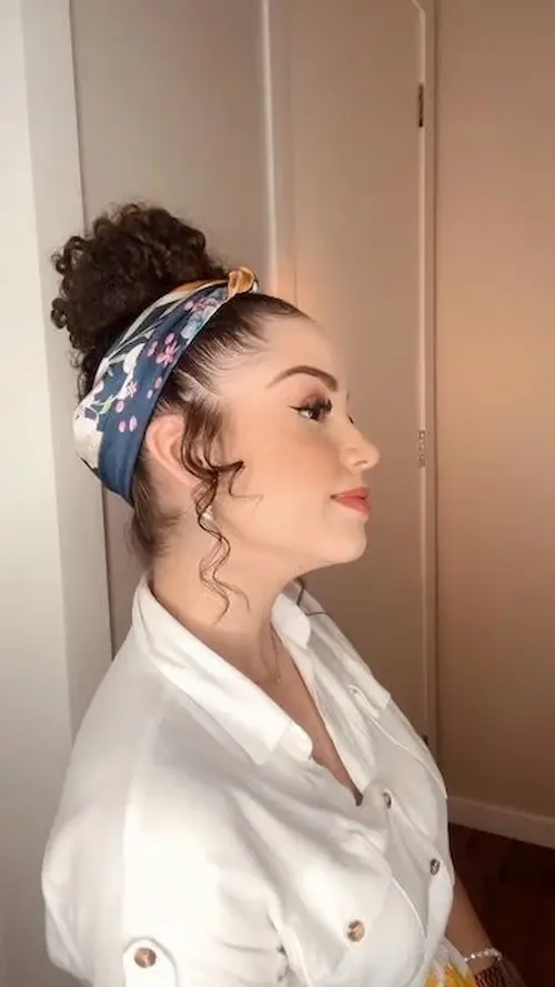Mulher com coque elegante usando lenço colorido azul, estilo moderno e casual.