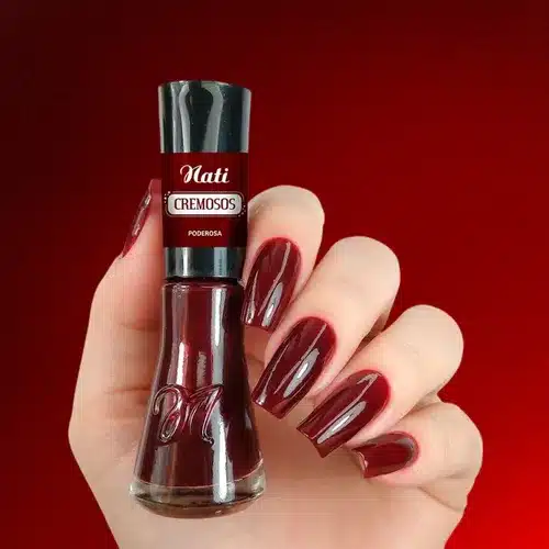 Unhas com esmalte bordô cremoso, com fundo vermelho e cor sofisticada.