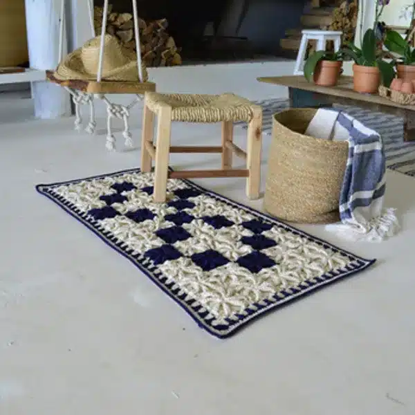 Tapete de crochê 3D com padrões geométricos em tons claros, ideal para ambientes com decoração escandinava.