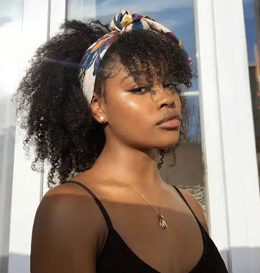 Mulher com cabelo cacheado usando faixa frontal colorida com lenço