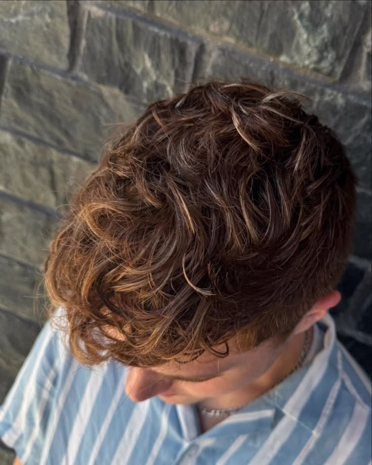 Cabelo masculino com luzes californianas em tons dourados, com estilo natural e moderno.