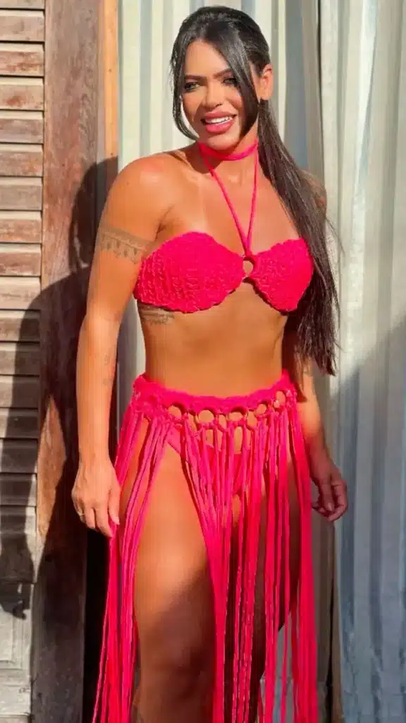 Mulher usando biquíni de crochê rosa neon com franjas