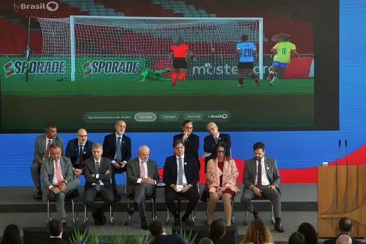 Cerimônia no Palácio do Planalto para assinatura do decreto que regulamenta a TV 3.0, com transmissão ao vivo de uma partida de futebol.