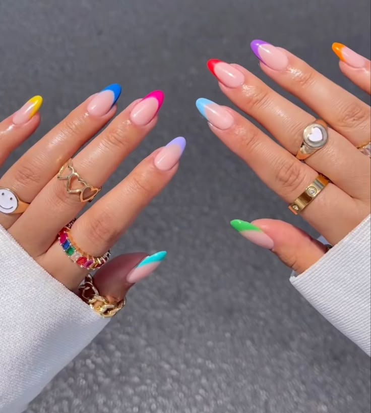 Mãos com unhas em formato de amêndoa, usando a técnica de francesinha colorida em diferentes tons vibrantes.