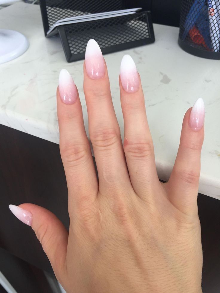 Unhas longas em formato oval com uma francesinha em degradê de branco e rosa.