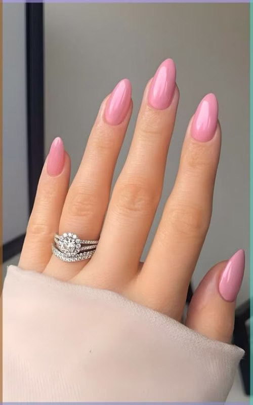 Unhas alongadas e esmaltadas com rosa chiclete em acabamento delicado