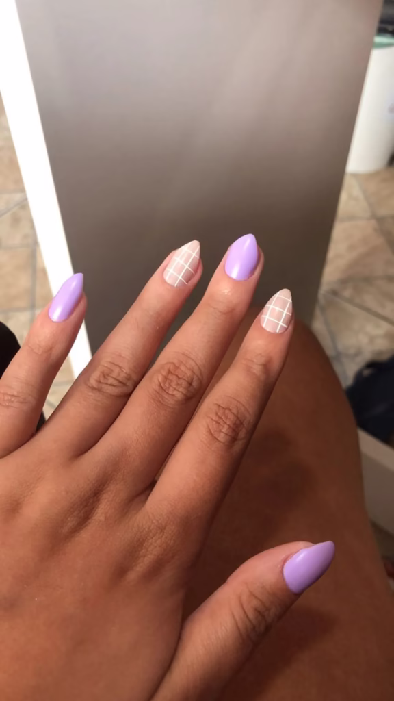 Unhas decoradas em lilás com detalhe geométrico branco nas unhas anelares e médias