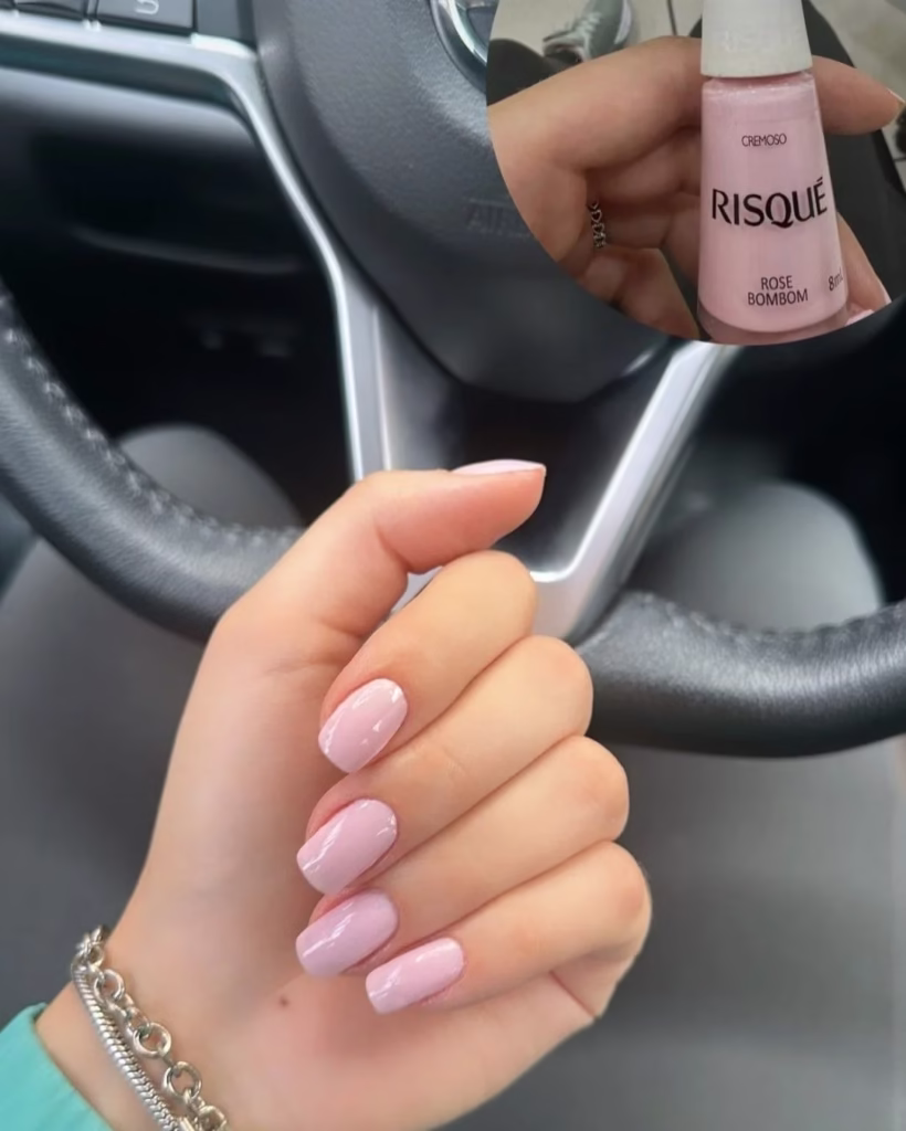 Imagem de unhas pintadas com esmalte rosa claro da Risqué Rose Bombom, com foco nas mãos e na cor das unhas.