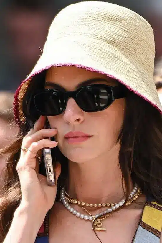 Anne Hathaway usando touca de crochê e óculos escuros nas gravações de 'O Diabo Veste Prada'