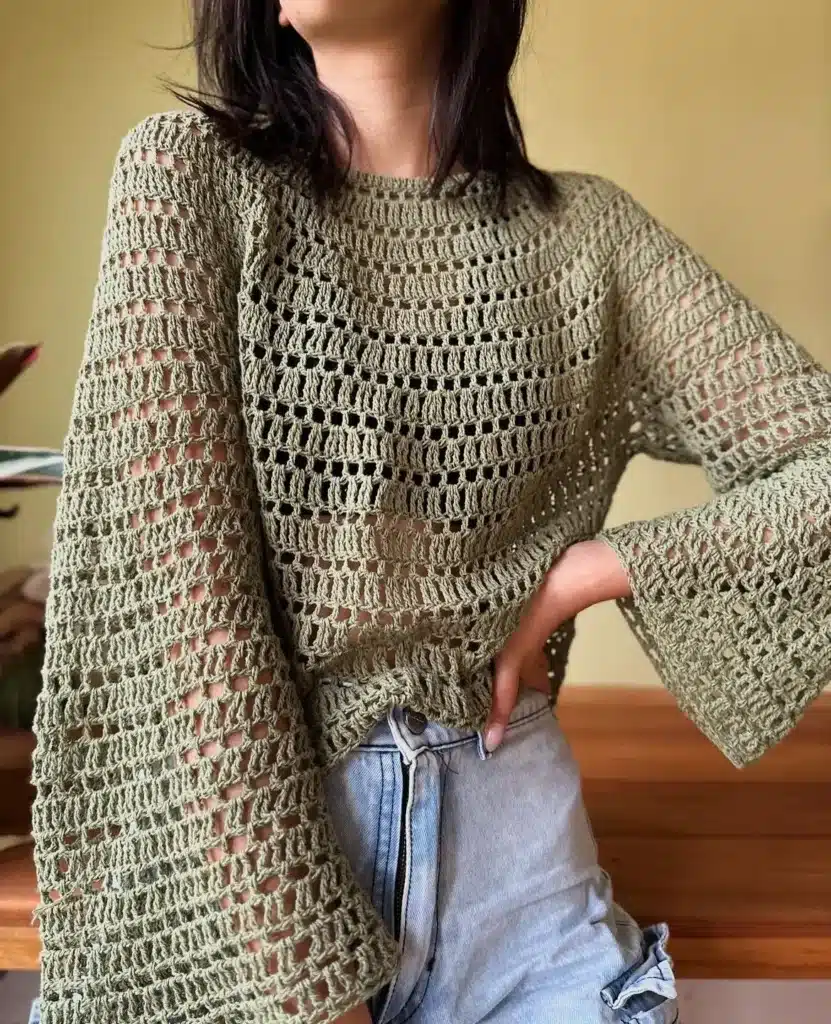 Mulher vestindo uma bata com mangas flare (boca de sino), exibindo estilo moderno e descontraído.