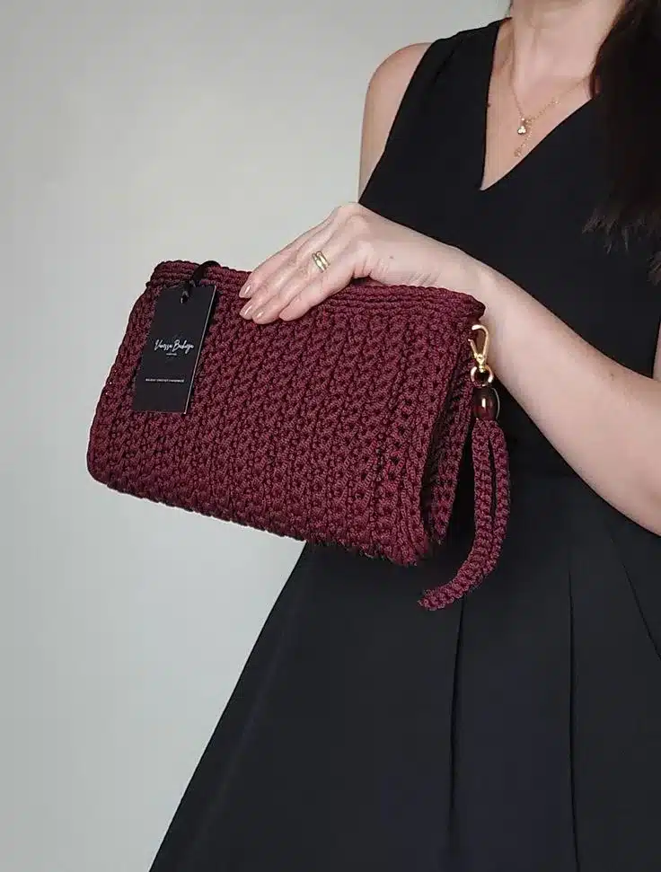 olsa clutch em crochê de cor vinho com detalhes em cordão, ideal para ocasiões especiais.
