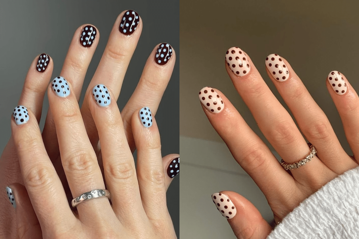Mãos com unhas decoradas com estampa de bolinhas (poá) em diferentes cores, uma em azul claro com bolinhas pretas e a outra em tom de nude com bolinhas marrons.