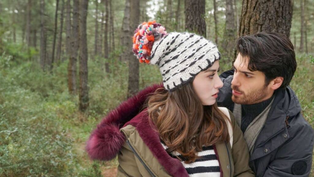 O ator Can Yaman e a atriz Özge Gürel, protagonistas da novela turca Dolunay, em uma cena romântica em uma floresta.