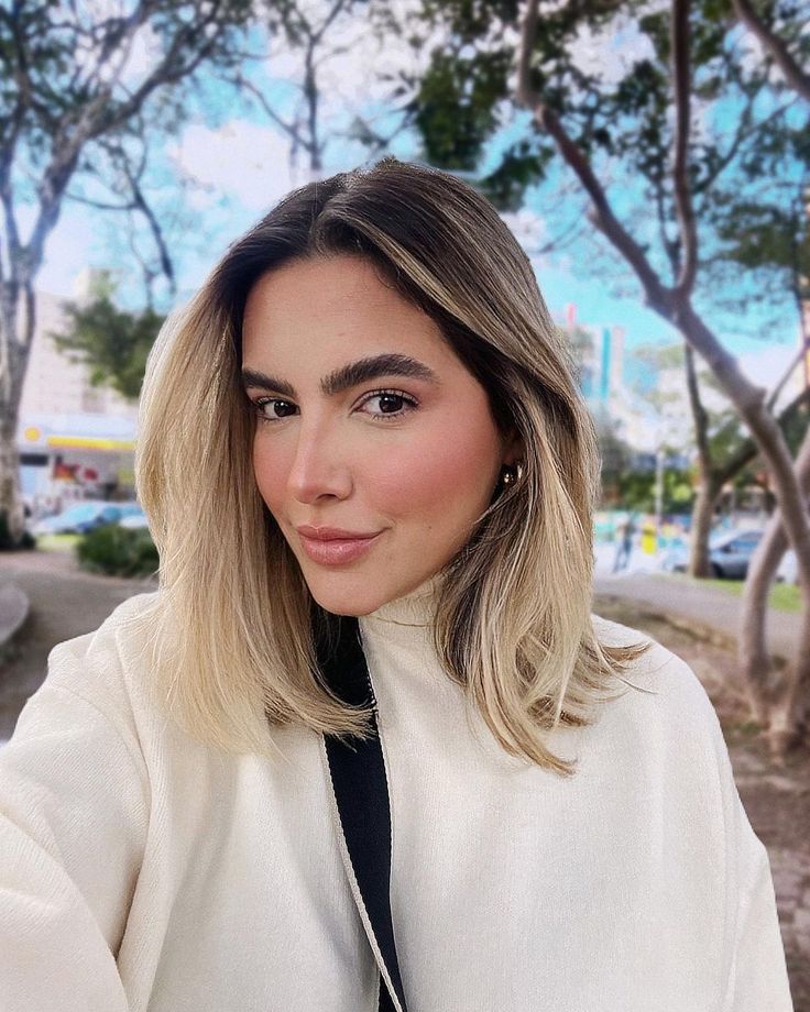 Corte long bob despojado com mechas loiras e raiz mais escura, um dos cortes de cabelo mais modernos para a primavera.